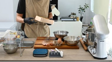 Bir insan mutfakta bir karıştırıcı ve bir kase yumurtayla yemek hazırlıyor. Mutfak, blender da dahil olmak üzere çeşitli alet ve gereçlerle dolu...