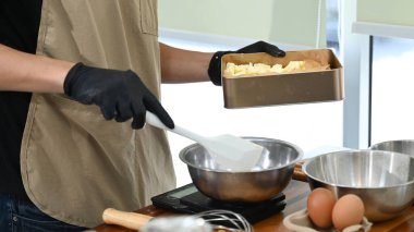 Bir insan mutfakta bir karıştırıcı ve bir kase yumurtayla yemek hazırlıyor. Mutfak, blender da dahil olmak üzere çeşitli alet ve gereçlerle dolu...