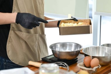 Bir insan mutfakta bir karıştırıcı ve bir kase yumurtayla yemek hazırlıyor. Mutfak, blender da dahil olmak üzere çeşitli alet ve gereçlerle dolu...