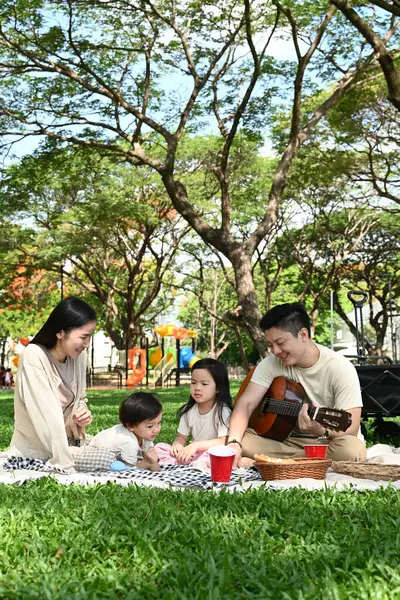 Dört kişilik bir aile parkta piknik yapıyor. Çocuklar yemek yerken adam gitar çalıyordu. Sahne mutlu ve rahat...