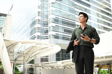 Bir adam elinde cep telefonuyla kaldırımda yürüyor...