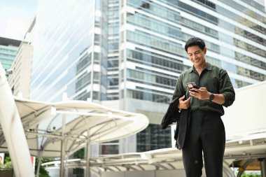 Bir adam elinde cep telefonuyla kaldırımda yürüyor...