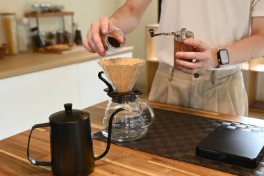 Damlalık sıcak espresso demleyen bir adam, sıcak suyla kahvenin üstüne kahve döküp mutfakta filtre kağıdı döken bir adam...