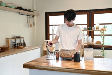 Damlalık sıcak espresso demleyen bir adam, sıcak suyla kahvenin üstüne kahve döküp mutfakta filtre kağıdı döken bir adam...