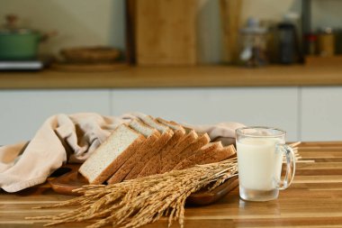 Arka planda meşe ağacından bir tahta ve mutfak havlusunun üzerinde kırsal ekşi ekmek dilimleri..