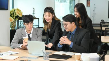 Bir dizüstü bilgisayar üzerinde çalışan iş ekibi...