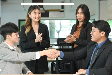 İş adamı ofiste görüştükten sonra iş arkadaşıyla tokalaşıyor..