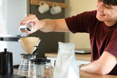 Adam sabah ışığında minimalist mutfakta manuel kahve yapıyor..