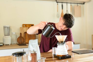 Adam mutfakta cam damlatıcı kullanarak kahve hazırlıyor..