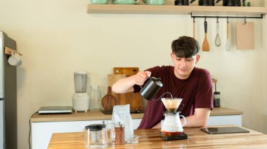 Adam mutfakta cam damlatıcı kullanarak kahve hazırlıyor..