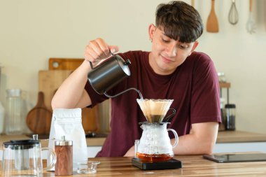 Adam mutfakta cam damlatıcı kullanarak kahve hazırlıyor..