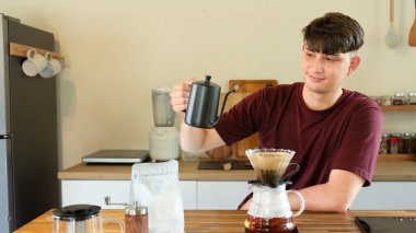 Adam mutfakta cam damlatıcı kullanarak kahve hazırlıyor..