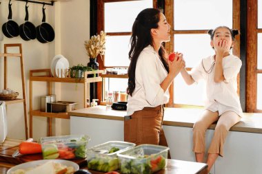 Anne kızı mutfak yemeği pişiriyor, çocuk pişiriyor, mutlu kızı bir araya getiriyor, evde ebeveynlik yapıyor..