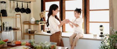 Anne kızı mutfak yemeği pişiriyor, çocuk pişiriyor, mutlu kızı bir araya getiriyor, evde ebeveynlik yapıyor..