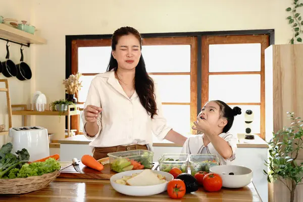 Anne kızı mutfak yemeği pişiriyor, çocuk pişiriyor, mutlu kızı bir araya getiriyor, evde ebeveynlik yapıyor..