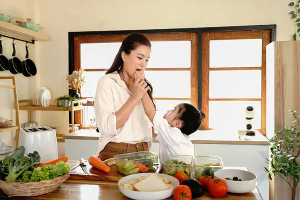 Anne kızı mutfak yemeği pişiriyor, çocuk pişiriyor, mutlu kızı bir araya getiriyor, evde ebeveynlik yapıyor..