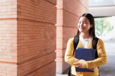 Elementary school student walking down a bright school hallway, heading back to class after enjoying recess, carrying a backpack and embracing the joy of learning.