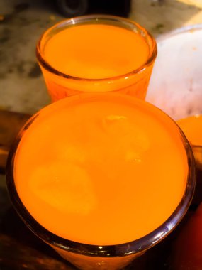 Arkaplanı bulanık olan portakal suyu bardakları. Arka planı bulanık iki sarı portakal suyu yakın plan görüntüsü. 