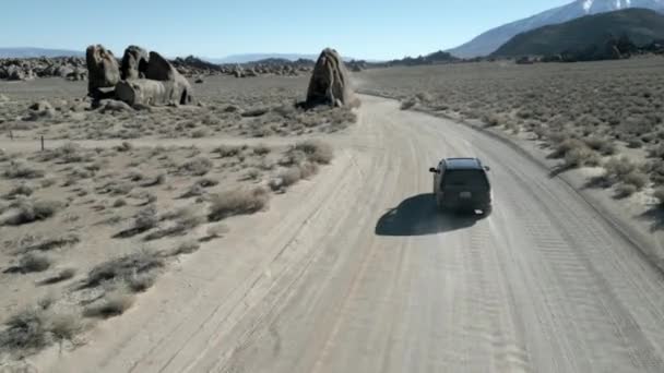 アラバマヒルズ周辺の岩を通って黒いSuvを追いかける砂漠 高品質 映像ローンパインムービーロード カリフォルニア アメリカ — ストック動画