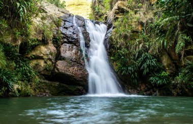 Nehirdeki cennet şelalesi kayalar ve bitkilerle çevrili..