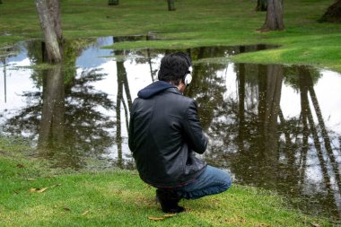 Rocker Tarzlı Genç Adam Doğa ve Bataklık Dinginliğinin Tadını Çıkartıyor Kulaklıkla