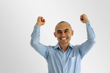 Genç mutlu iş adamı ellerini kaldırıp gülümsüyor.