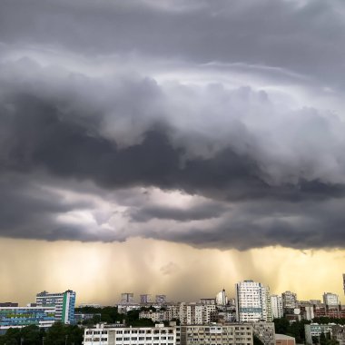Kasırgadan önce şehrin üzerinde kara fırtına bulutları ile dramatik uğursuz gökyüzü. Güçlü rüzgar, kara bulutları yönlendiriyor. Kötü hava, korkunç doğa olayları. Doğal arkaplan