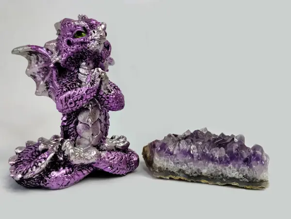 Mor Ejderha figürü, Ejderha 'nın yönetiminde yeni yılda tüm insanların iyiliği için dua eder. Bir ametist kristalinin yanında duruyor.