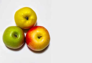 Beyaz arkaplanda izole edilmiş sarı, kırmızı ve yeşil elmalar metin, üst görünüm için kopyalama alanı