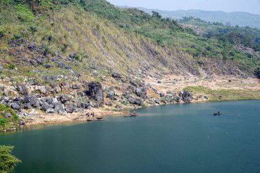 Bangladeş 'in Sunamganj kentindeki Niladri Gölü manzaralı bir manzarada, teknelerdeki yerel balıkçılar büyüleyici tepe ve sakin mavi sulara karşı balık yakalarken görülüyor. Bangladeş-Hindistan sınırı yakınlarındaki bu güzel doğal ortam.