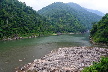 Hindistan 'ın Meghalaya kentindeki Shnongpdeng kentinden çarpıcı bir nehir manzarası, kristal berrak suları, yemyeşil çevresi ve dingin doğal güzelliğiyle tanınıyor. Dawki yakınlarındaki Jaintia Tepeleri 'ne yerleşmiş olan bu nehir kenarı, tekne ve kamp için gözde bir yerdir.
