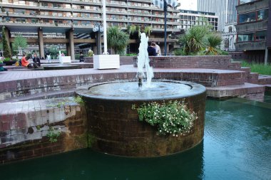 Havuzun ortasında bir çeşme başı olan bir çeşme.