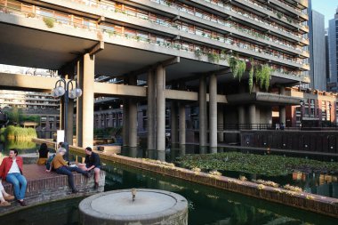 Nehrin yanındaki bankta oturan bir grup insan.