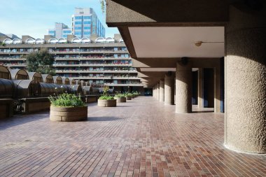 Saksıları ve bankları olan tuğla bir yürüyüş yolu.