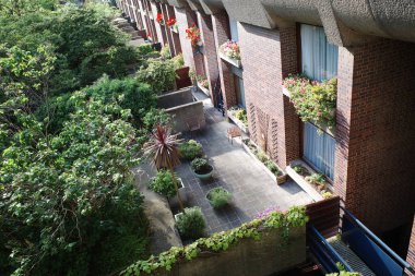 Bir sürü bitki ve mavi banklı bir balkon.