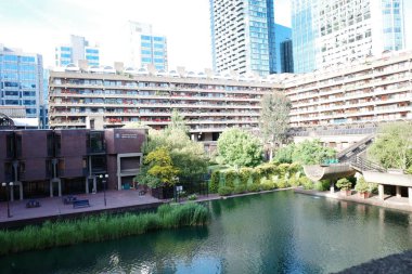 Şehir boyunca akan bir nehir, yüksek binaların yanında.