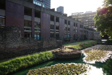 Şehir boyunca akan bir nehir, yüksek binaların yanında.
