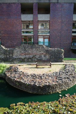 Bir gölün yanındaki taş duvarda bir bank.