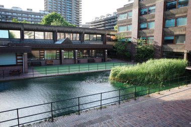 Şehir boyunca akan bir nehir, yüksek binaların yanında.