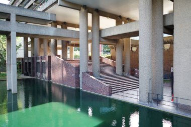 Havuzu ve duvarında saati olan bir bina.