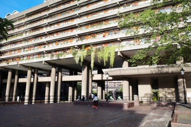 Bir sürü penceresi ve etrafta dolaşan bir sürü insan olan bir bina.