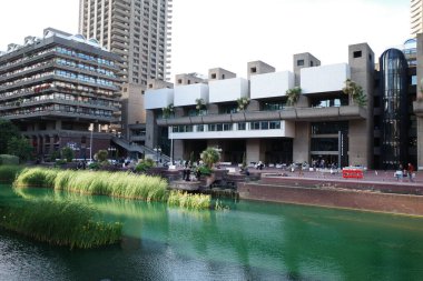 Şehir boyunca akan bir nehir, yüksek binaların yanında.