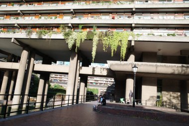 Önünde yürüyüş yolu olan bir bina ve önünde de bir yürüyüş yolu.