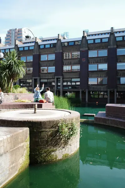 Bir bankta oturan bir çift insan bir su kütlesinin yanında.