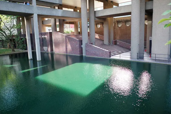 Yeşil yüzeyi ve merdivenleri olan bir havuz.