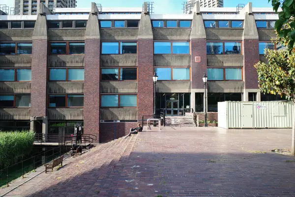 Üzerinde saat olan bir binaya giden tuğladan bir geçit.