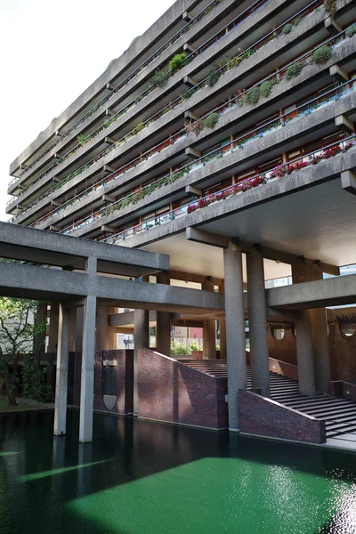 Önünde yeşil havuz olan bir bina.