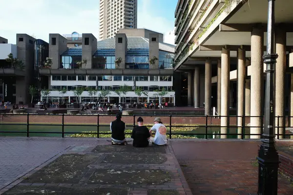 Birkaç kişi bankta oturuyor.