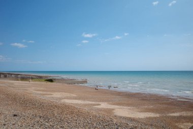 Üzerinde birkaç kişinin yürüdüğü bir kumsal.