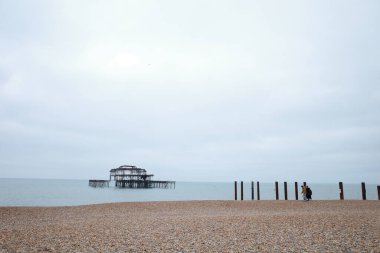 Sahilde, iskelenin yanında duran biri.